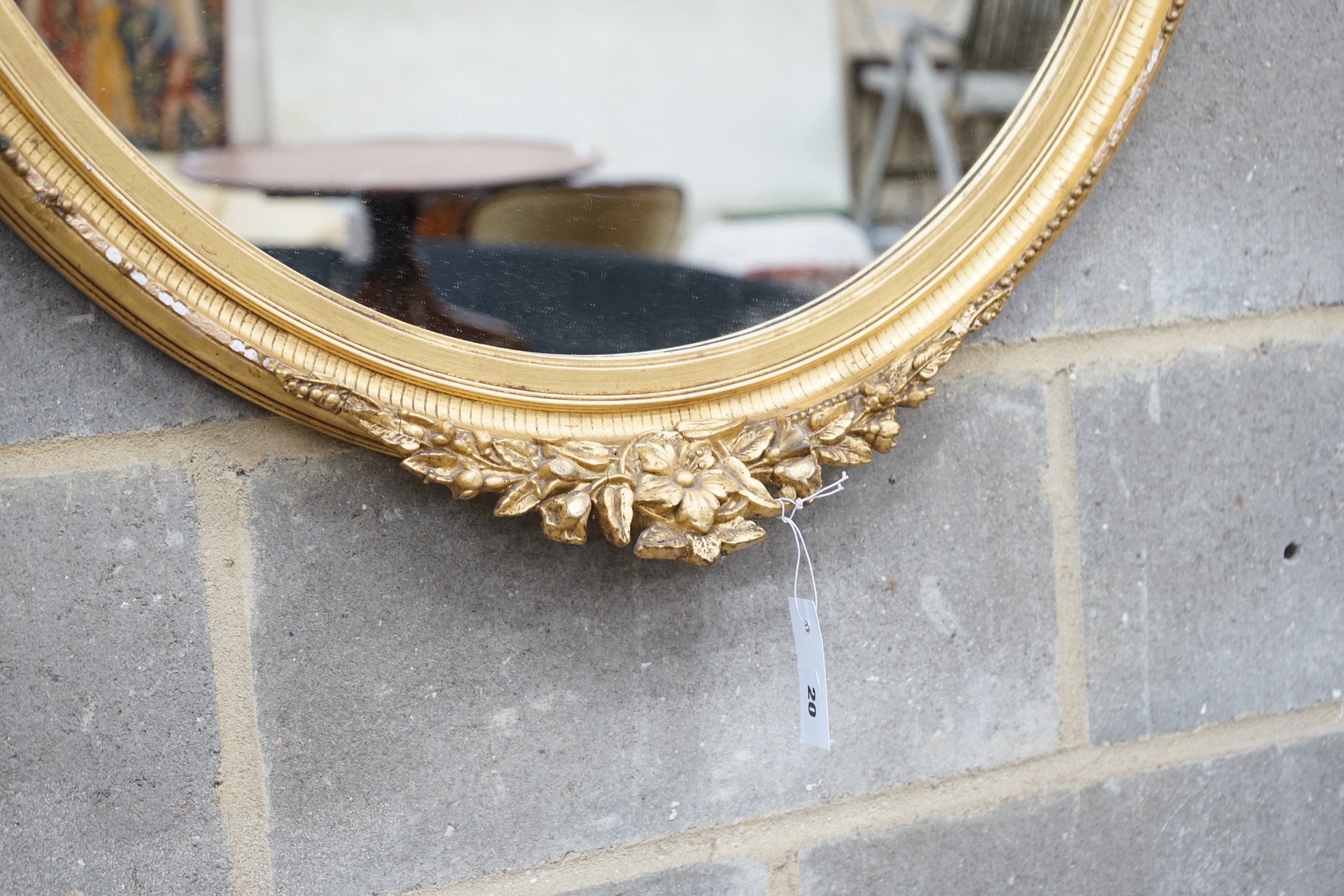 An early 20th century gilt wood and gesso oval wall mirror width 75cm height 96cm.